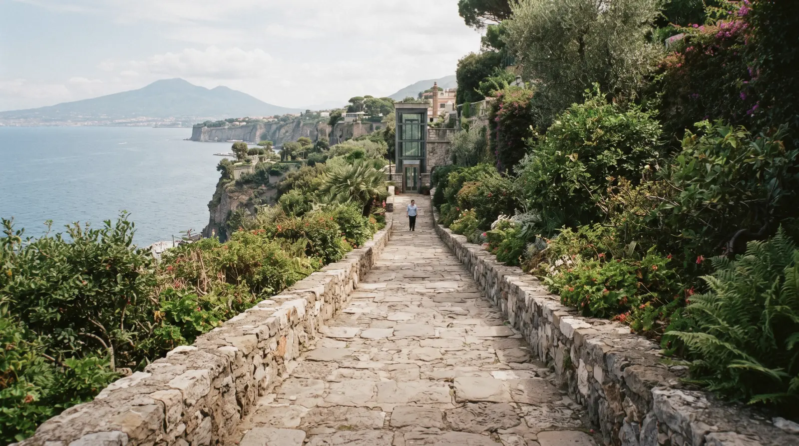 The wide, level path across Sorrento's Villa Comunale gardens with the bay in the background
